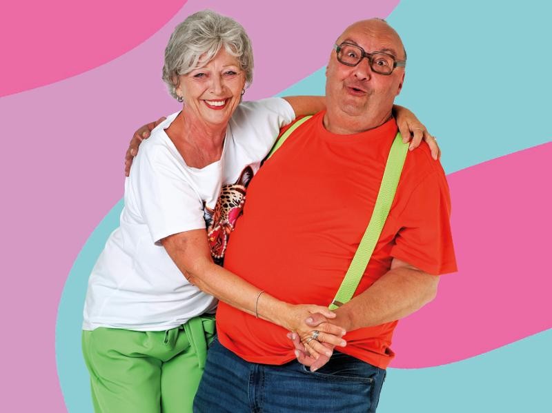 Kächeles Ute Landenberger als "Käthe" und Michael Willkommen als "Karl-Eugen" vor buntem Hintergrund.