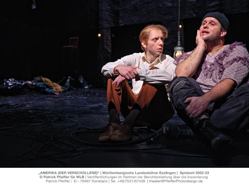 Szene aus Theaterstück Amerika: zwei Männer sitzen am Boden